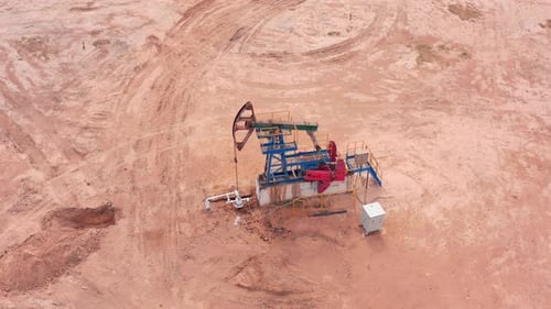 Oil Pump Jack in Desert Landscape with Extraction Equipment
