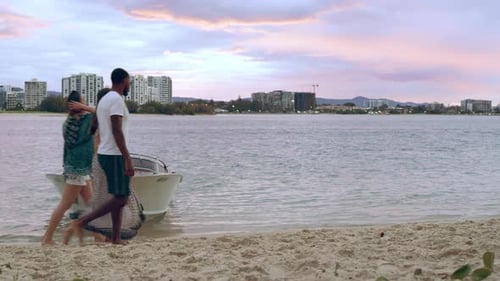 Friends enjoying a sunset walk on an australian beach near a boat