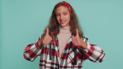 Teen Girl Giving Thumbs Up on Blue Background