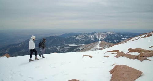 Couple hiking to summit of rocky mountains on beautiful Colorado day