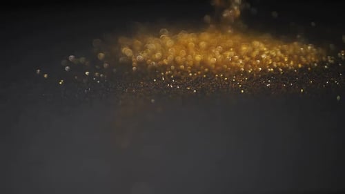 Gold dust falls on a black background
