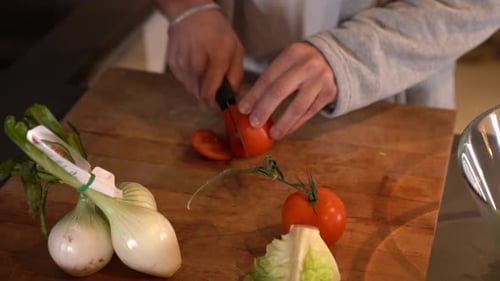 Hands Slice Fresh Tomato on Cutting Board
