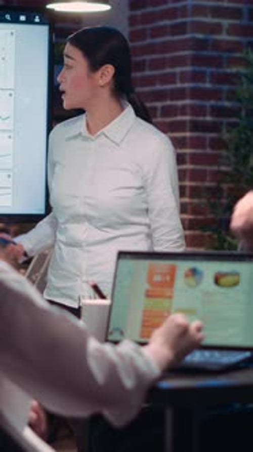 Woman Presents Charts to Colleagues in Modern Office