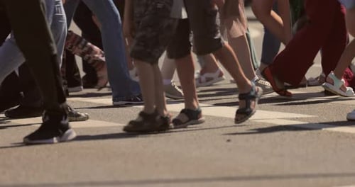 Os pés das pessoas na faixa de pedestres.