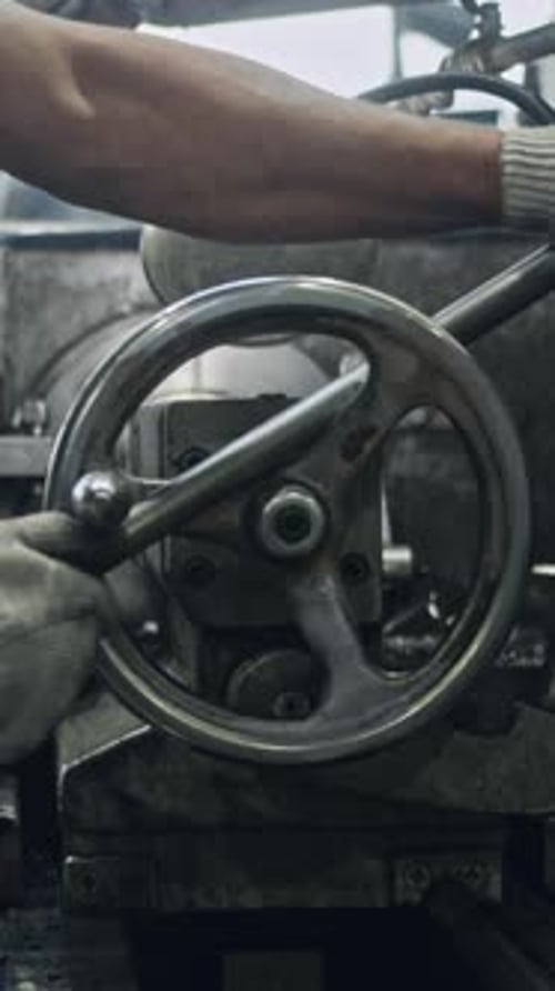 Expert worker using lathe machine in factory