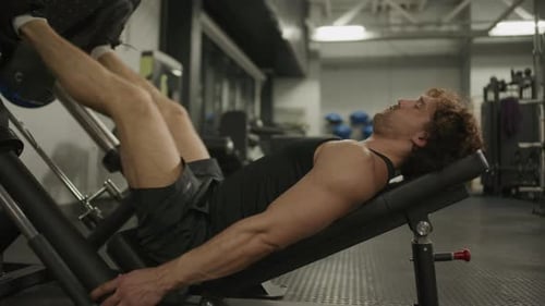Strong Man Doing Leg Press on Gym Machine during Lower Body Workout
