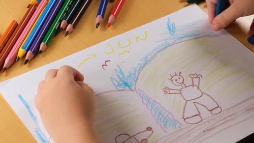 Child Drawing Colorful Picture on Paper at Home