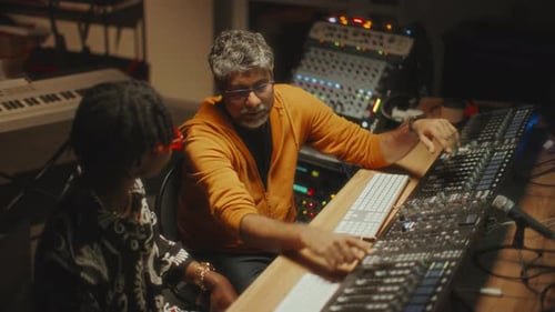 Sound Engineer Explaining Audio Production Details to Musician in Studio