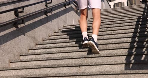 Man in sportswear running up on stairs outdoors, low angle view