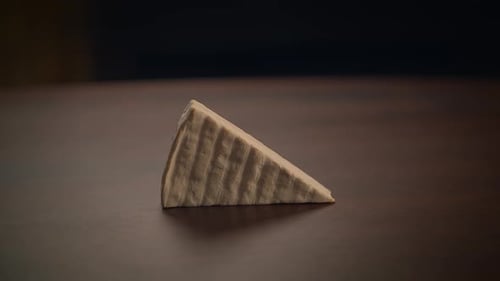 Hand Picks Up Cheese Wedge on Table