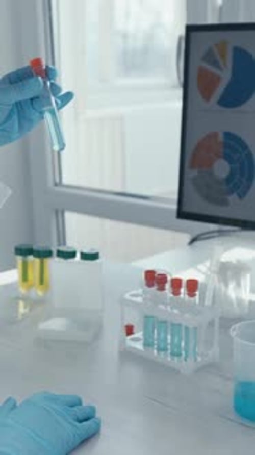 Gloved Hand Placing Test Tube in Rack