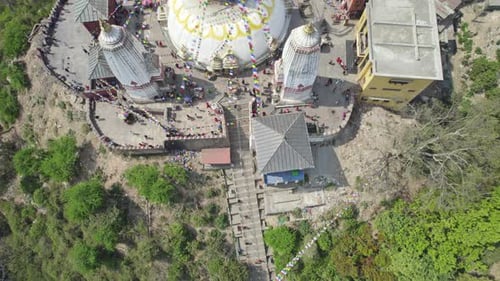 Vue aérienne mettant en valeur la flèche dorée du stupa de Swayambhunath et la ville animée de Katmandou.