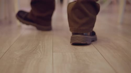 CloseUp of Man Walking on Wooden Floor with Brown Shoes and Motion Blur