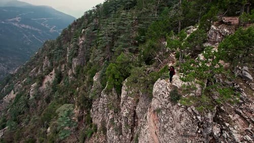 Adult Photographing Stunning Mountain Vista From Cliff