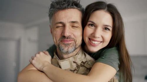 Loving Woman Embracing Soldier at Home