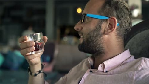 Happy, Young Man Relaxing and Drinking Sangria Wine in Cafe 30s