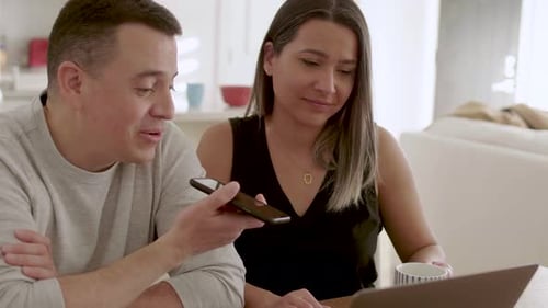 Couple uses laptop and phone in their home