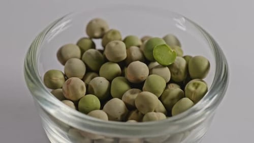 dried green peas in small glass bowl, 4k, parallax shot.