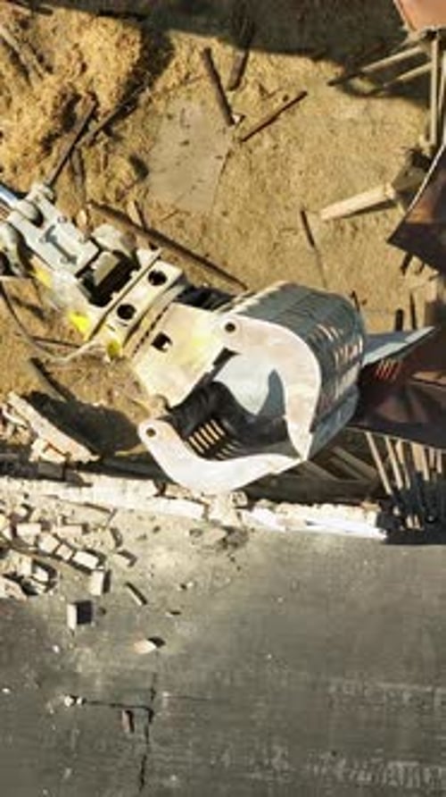 Vue aérienne de haut en bas d'un bâtiment de démolition d'une griffe d'excavatrice