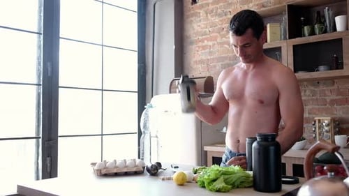 Yong Athlete Man Preparing Protein Shake In Kitchen