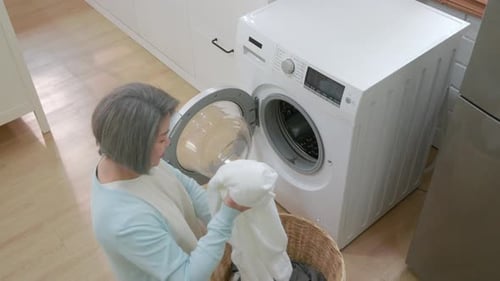 Senior Woman Doing Laundry in a Bright Kitchen