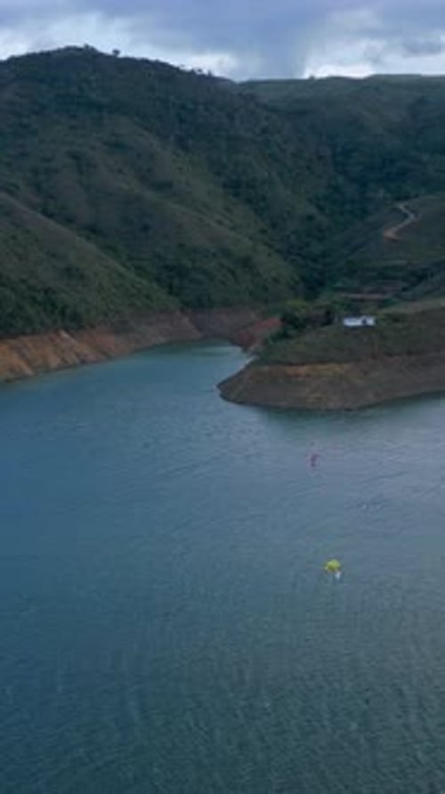 Aerial Lake Calima at Sunset with Kiteboarders at Distance. Pull Back Shot. Valle del Cauca. Colombi