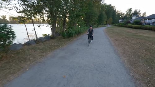 Adventure Woman Bike Riding on a Bicycle Trail Surrounded By Green Trees