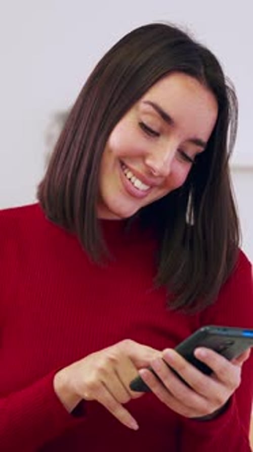 Smiling Woman Using Mobile Phone Indoors