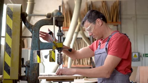 Focused Carpenter Drilling Steel in Professional Workshop