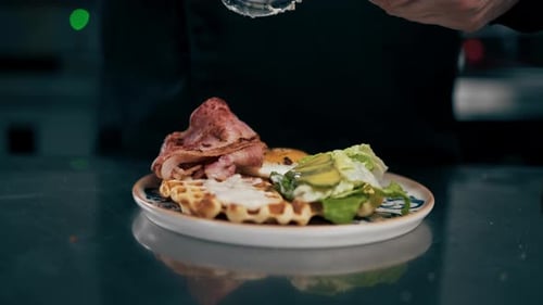Close Up in a Professional Kitchen a Chef in Black Jacket Assembles a Vegetable Souse Belgian Waffle