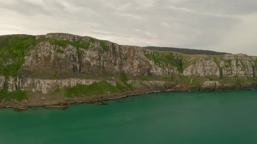 Orbiting shot left to right of cliffs along the coast in New Zealand