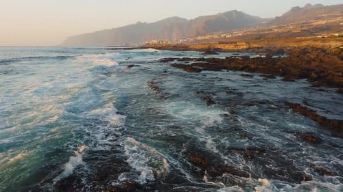 Soft Sunset Light Reflected in the Ocean Water and Illuminates Rocky Shore