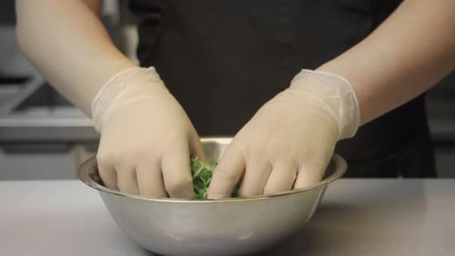 In Kitchen Man's Hands are Wearing Gloves As They Sort and Mix a Salad of Fresh Herbs Close Up Slow