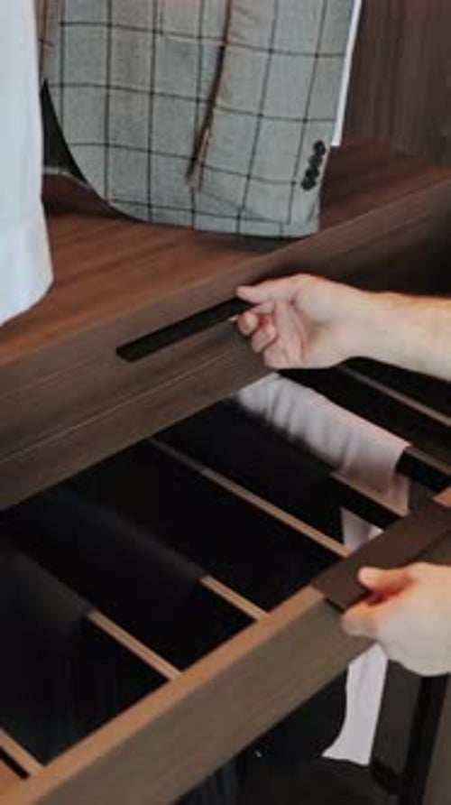 Closeup of a Hand Carefully Opening a Drawer and Taking a Belt From a Modern Wardrobe