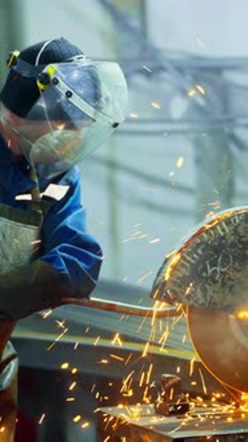 Skilled Worker Cuts Metal with Precision in Industrial Workspace