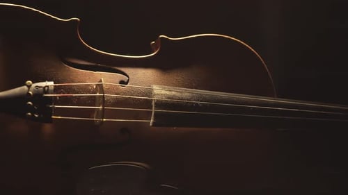 Nahaufnahme alter Geige, dramatisch Lichtwechsel über dem Instrument, Musikvideo der klassisch Symphonie