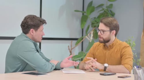 Men Discussing Business at a Table Indoors