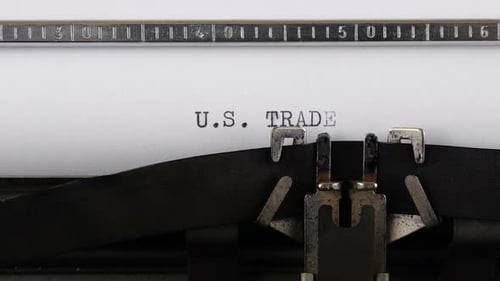 The phrase U.S. TRADE is typing on a retro typewriter.