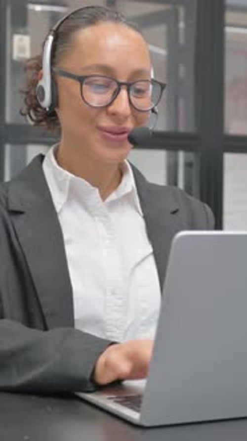 Smiling Woman in Office Video Conferencing on Laptop