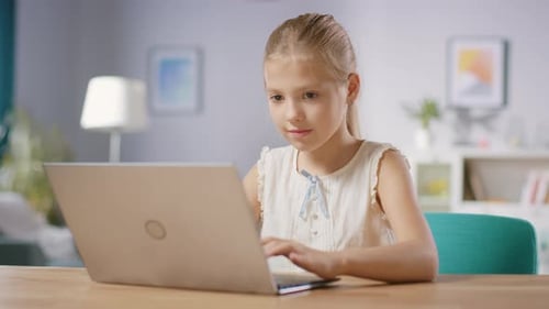 Focused Girl Typing on a Laptop at Home