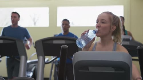 Woman hydrating after intense workout at the gym for a healthy lifestyle