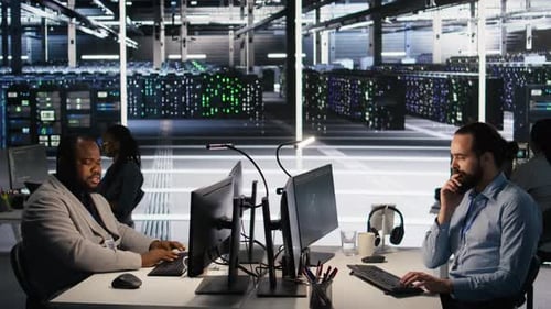 Data Center Technician Discussing with Coworker in Workspace