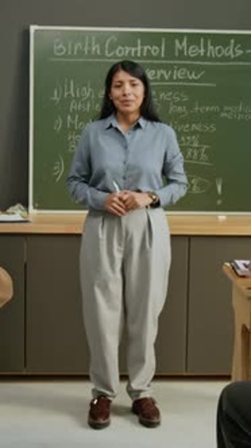Retrato de una maestra dando clases sobre métodos anticonceptivos en la escuela