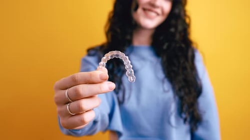 Woman Showing Clear Dental Aligner for Teeth