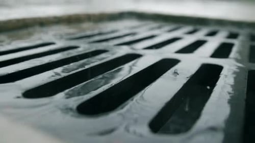 Rainy Day Drainage: Water Flowing into Street Drain
