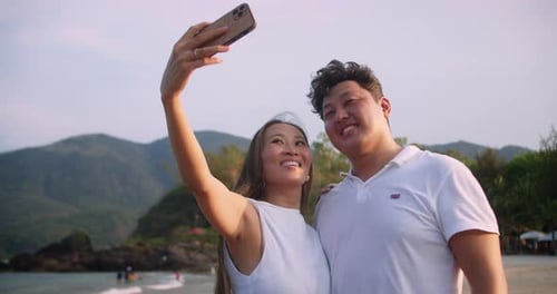 They Pose Together with Love Set Against a Stunning Tropical Sunset By the Ocean Capturing Their Joy