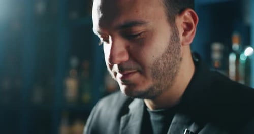 De perto, um barman profissional está preparando um coquetel alcoólico com cubos de gelo para o cliente