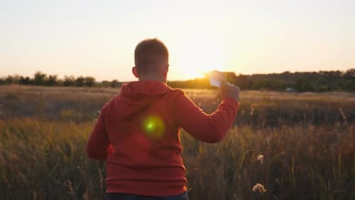 Small Boy Jogging with a Paper Airplane Through Grass Field Carefree Little Child Running with Toy