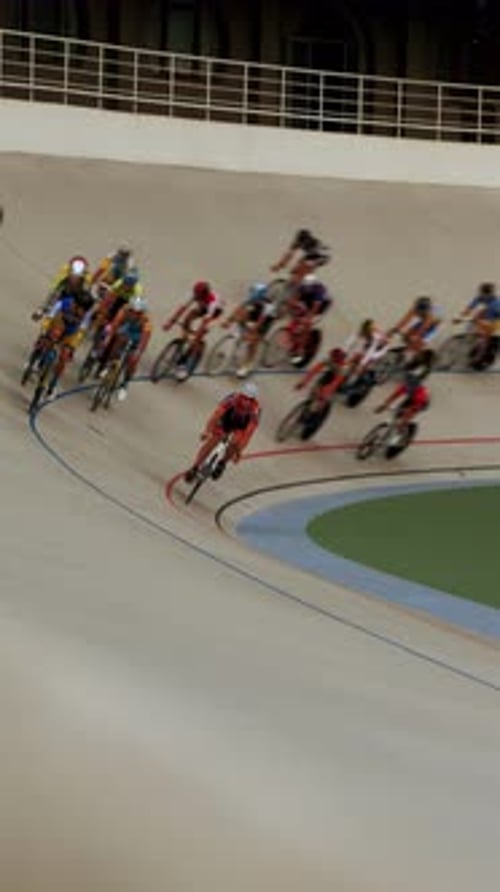 Velodrome. Cyclists riding track bicycles. Vertical video