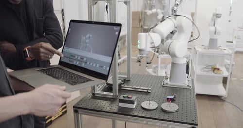 Équipe programmant un bras robotique